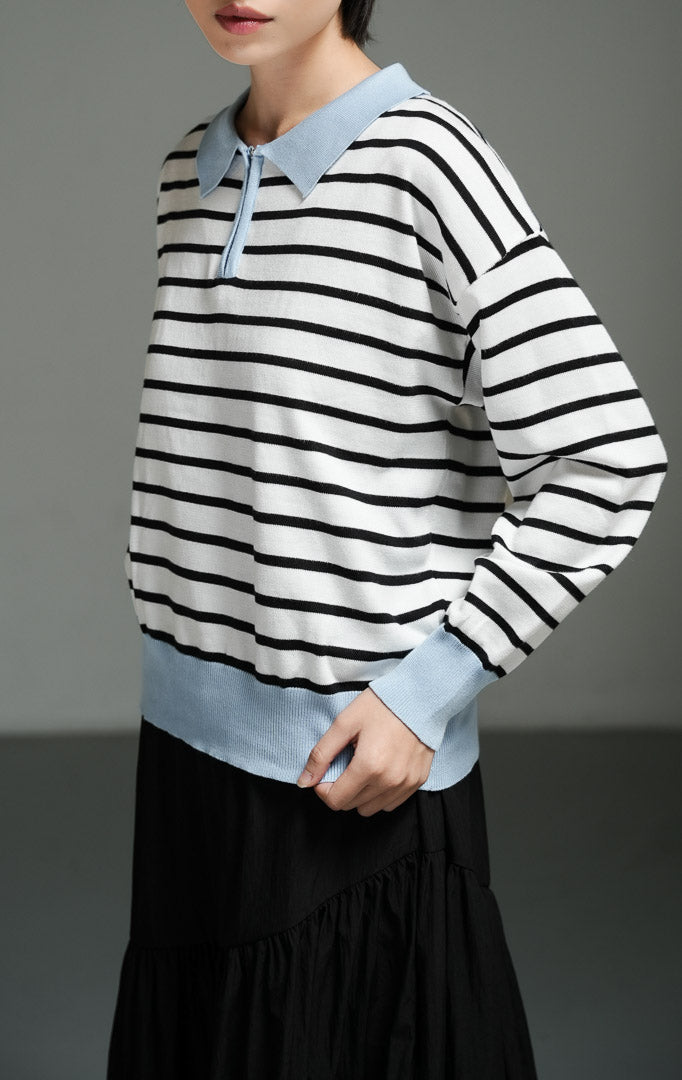 Atasan wanita model sweater rajut polo lengan panjang motif garis dengan kerah dan ritsleting setengah (white striped half-zip polo knit sweater) Zareon Sweater yang memberikan sentuhan kasual namun chic.
