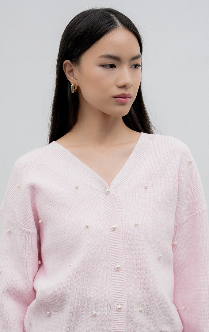Kardigan rajut wanita lengan panjang warna pink Vanessa Cardigan dengan kerah V (V-neck), bukaan kancing depan, dan aksen hiasan mutiara (scattered pearl details).
