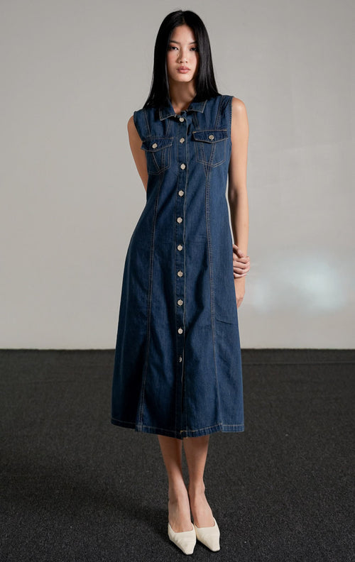 Vivienne Dress Dark Denim, gaun jeans tanpa lengan warna biru tua dengan kerah kemeja dan kancing perak di bagian depan.