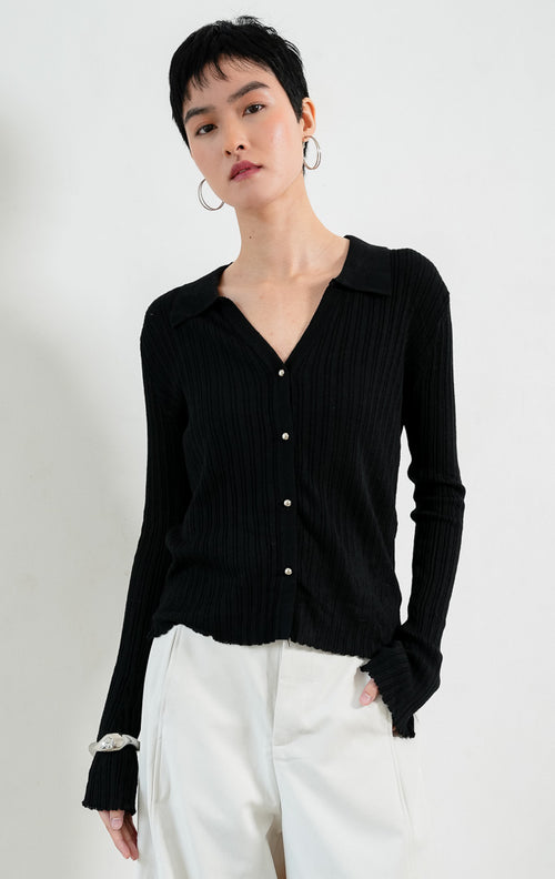 Kardigan rajut wanita lengan panjang warna hitam (black) Wetherley Cardigan bertekstur salur (ribbed knit) dengan kerah V berkancing depan, lengan mekar (trumpet sleeves), dan detail pinggir kerut (scalloped edges).