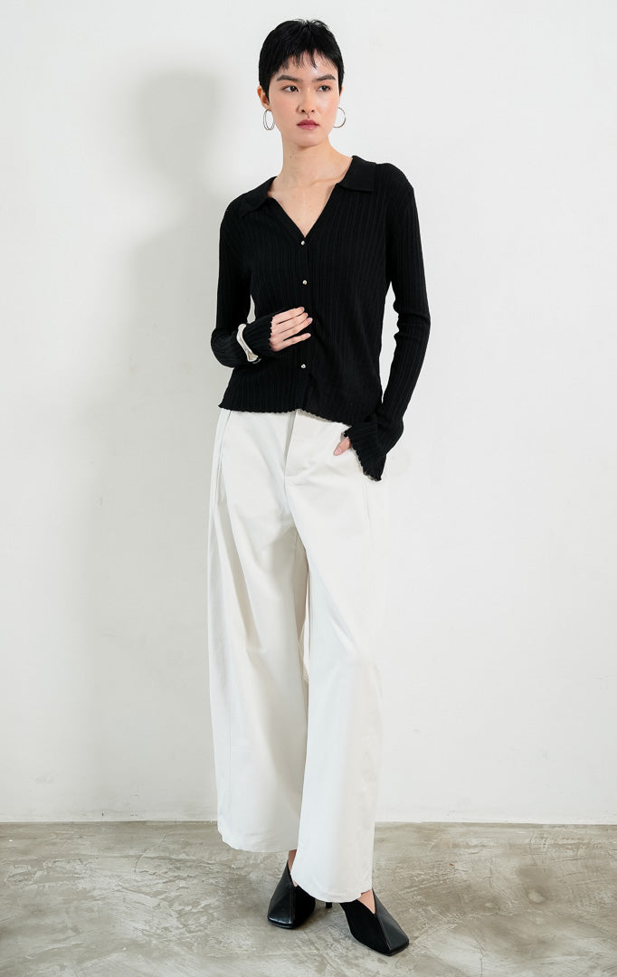 Kardigan rajut wanita lengan panjang warna hitam (black) Wetherley Cardigan bertekstur salur (ribbed knit) dengan kerah V berkancing depan, lengan mekar (trumpet sleeves), dan detail pinggir kerut (scalloped edges).