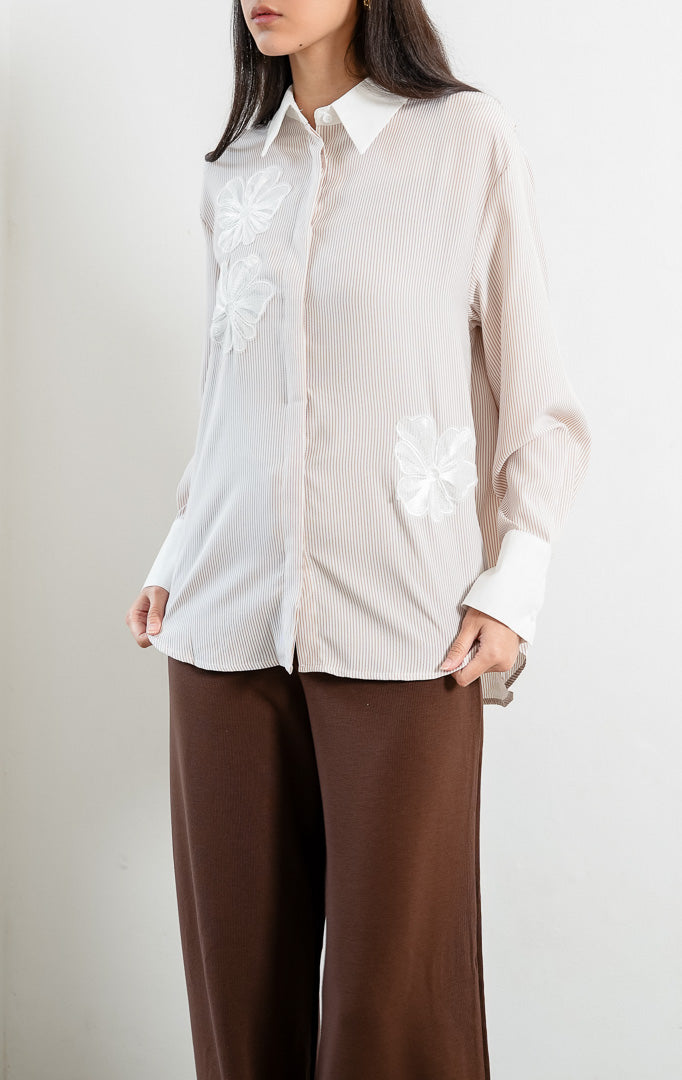 Kemeja wanita lengan panjang motif garis-garis cokelat (brown vertical stripes) Wilfred Top dengan detail aplikasi bordir bunga (embroidered floral motifs), kerah dan manset kontras putih (contrasting pointed collar and cuffs), serta bukaan kancing depan.