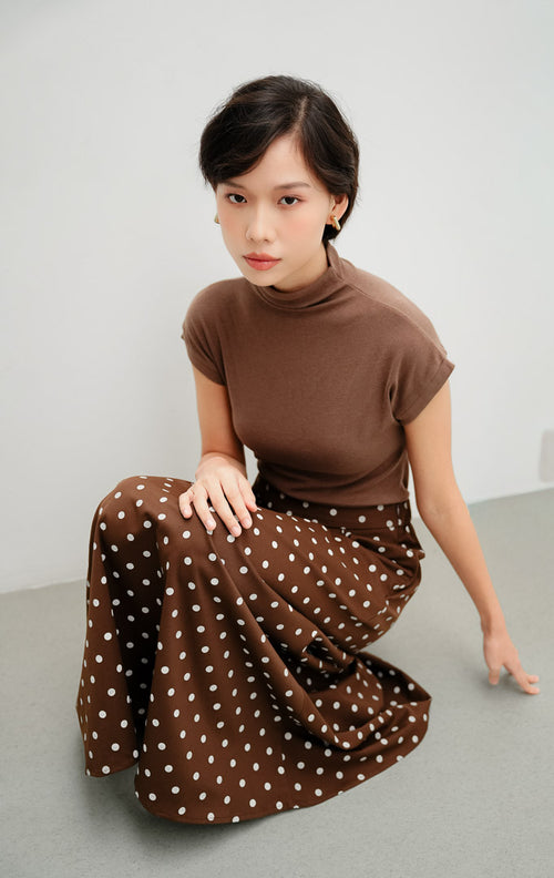 Rok panjang wanita model A-line (flare skirt) warna cokelat tua (dark brown) Willona Skirt berbahan katun motif polkadot dengan pinggang karet (elastic waistband).
