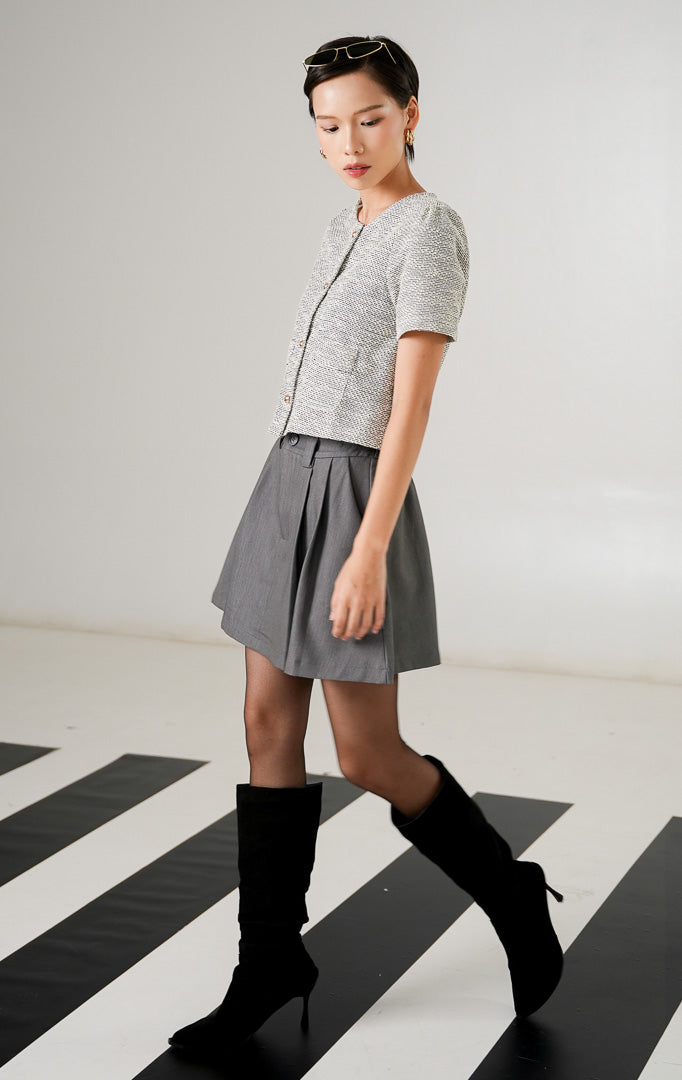 Atasan rajut wanita Zoya Top Grey dengan tekstur motif tweed, lengan pendek, kancing emas vertikal, dan saku dekoratif depan dari This Is April.