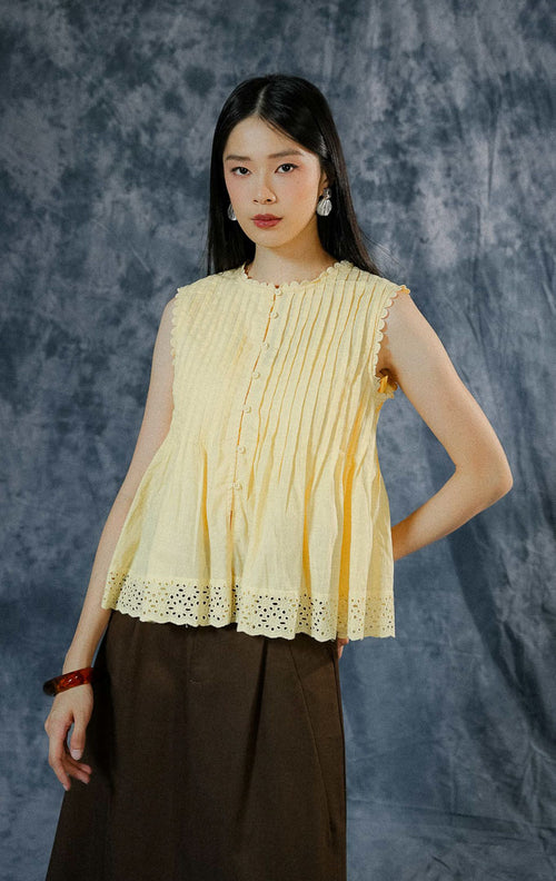 Atasan tanpa lengan wanita Misty warna kuning (yellow) berpotongan peplum, menampilkan detail lipit pintuck dada, aksen sulam (embroidery), dan kancing depan hidup. 