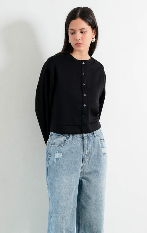 Jaket wanita lengan panjang model cropped warna hitam (black) Arsela Jacket berbahan katun jersey (cotton jersey) dengan kerah bulat (round neckline) dan bukaan kancing cetet sewarna (tonal snap-button closure).