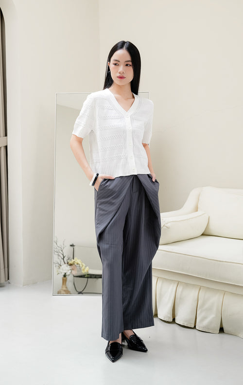 Atasan rajut wanita warna putih Maysie Top dengan motif rajut geometris lattice, kerah V-neck, lengan pendek, dan kancing depan elegan. 