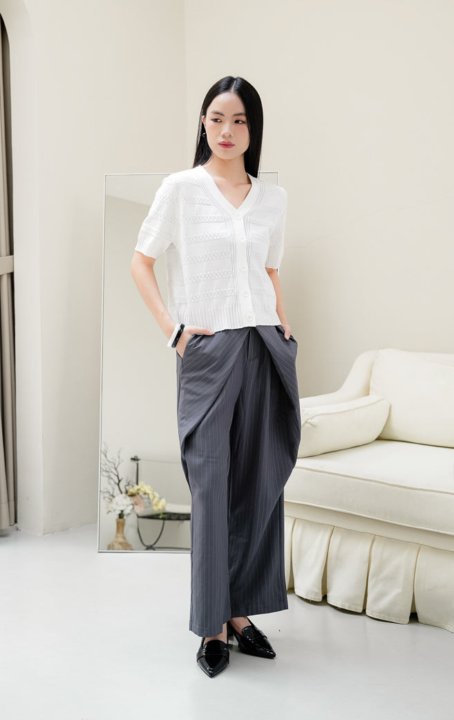 Atasan rajut wanita warna putih Maysie Top dengan motif rajut geometris lattice, kerah V-neck, lengan pendek, dan kancing depan elegan. 