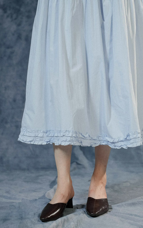 Rok panjang (maxi skirt) wanita Lacey warna biru berbahan katun dengan detail tingkat (tiered), jahitan bergelombang di tengah, aksen ruffle bawah, dan pinggang karet.
