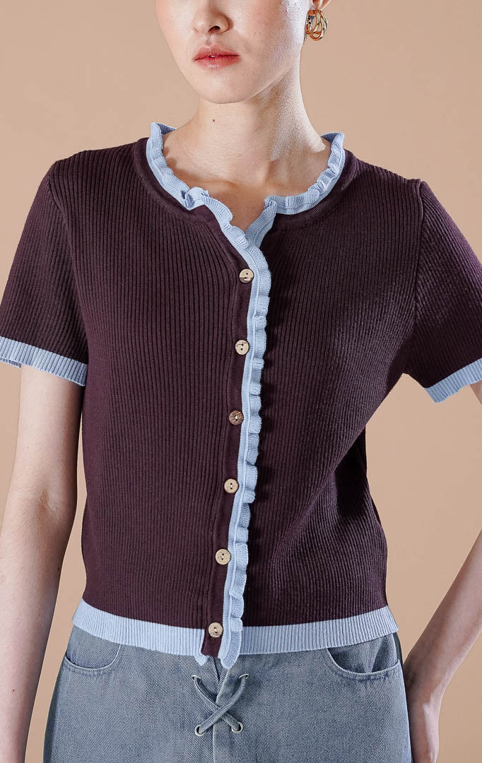 Amalia Top Dark Brown, atasan rajut lengan pendek warna cokelat tua dengan detail trim kerut warna biru muda pada kerah, tengah baju, dan ujung lengan.