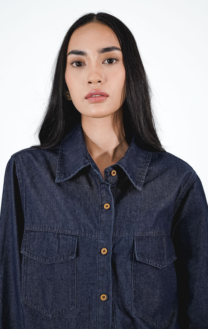  erve Top warna dark denim, kemeja jeans lengan panjang dengan dua saku dada dan ujung bawah rawis (frayed hem), dipadukan dengan rok mini krem.1