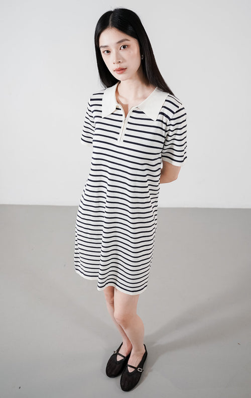 Kayona Dress warna ivory, mini dress rajut lengan pendek motif garis horizontal hitam dengan detail kerah polo putih dan resleting depan.