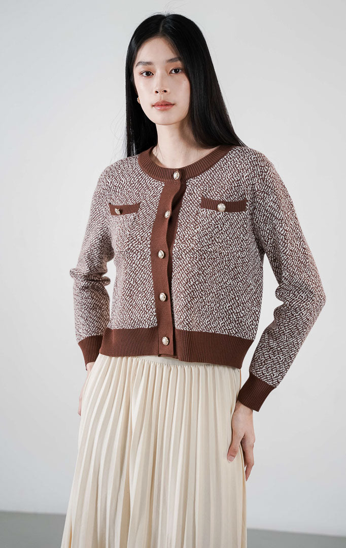 Monique Cardigan warna dark brown, kardigan rajut pola dua warna dengan detail garis hitam kontras, dua saku dada, dan kancing emas bulat di bagian depan.Nathaniel 