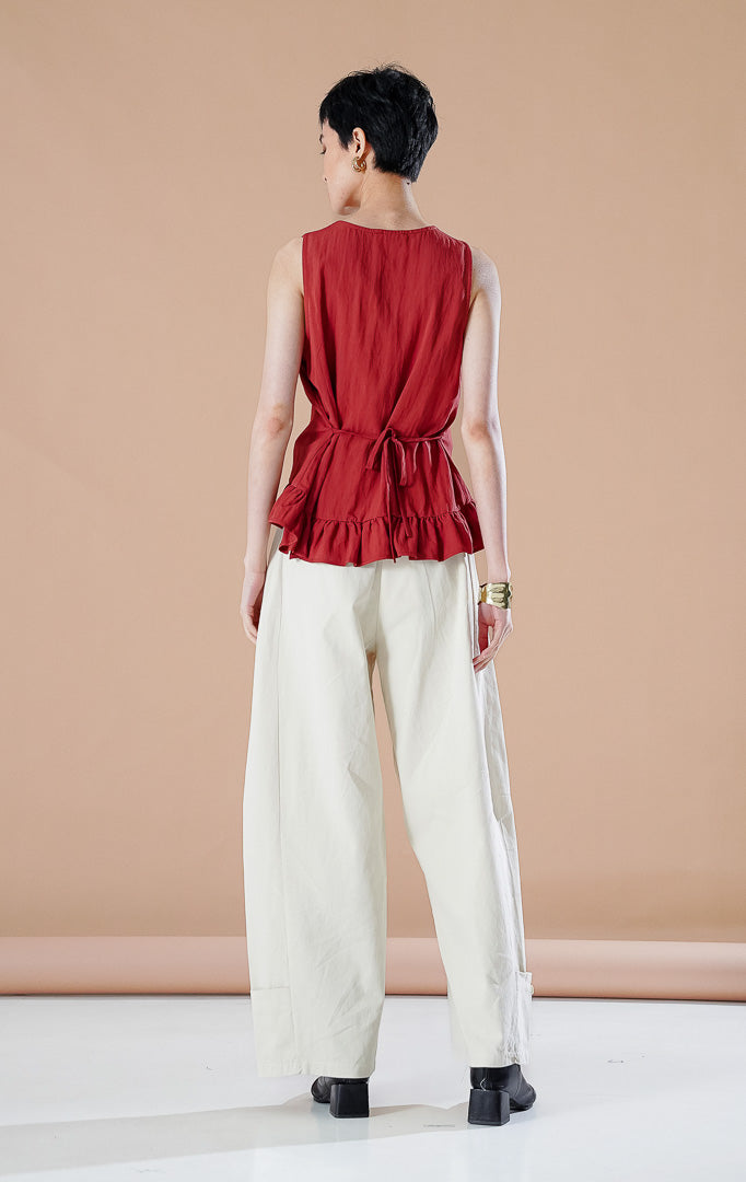Atasan wanita Odellia Top warna Terracotta dengan detail peplum rampel, kancing depan aktif, dan tali samping yang dapat disesuaikan untuk gaya kasual elegan