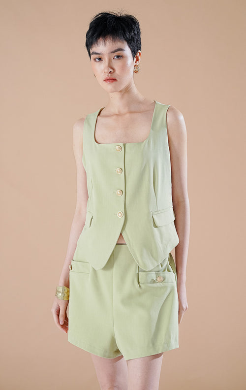 Setelan wanita Pepper Set warna Sage Green yang terdiri dari blazer tanpa lengan terstruktur dengan kancing depan dan celana pendek senada.