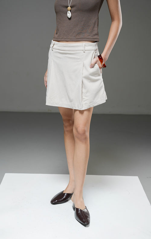 Rok celana wanita Leuana Skort warna ivory krem berbahan corduroy dengan detail pleat lipatan depan dan bagian celana tersembunyi di dalam.