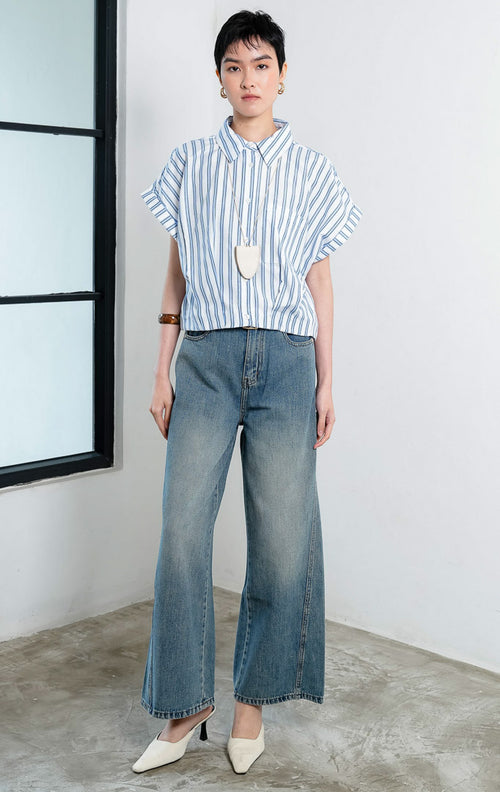 Kemeja crop wanita lengan pendek motif salur biru putih (blue white striped) Addie Top dengan kerah kemeja (pointed collar), bukaan kancing depan, saku depan (patch pocket), dan kelim melengkung (curved hem).