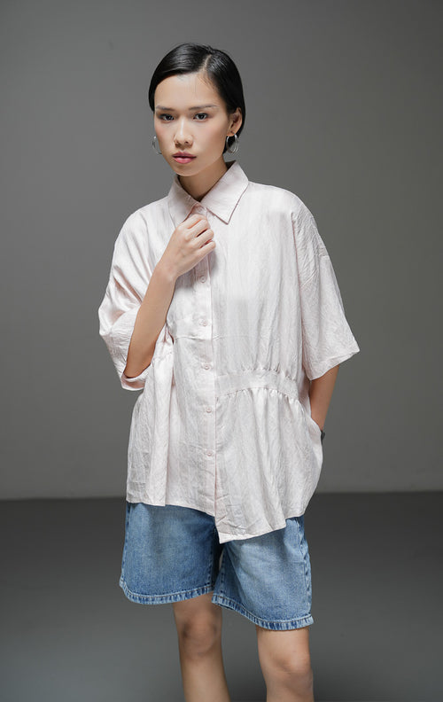 Kemeja oversized wanita Adella Top warna pink pastel bahan katun bertekstur garis dengan kerah kemeja dan kancing depan. 