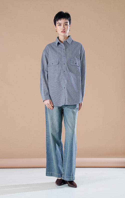Adriana Shirt kemeja button up bermotif garis dark denim dengan dua saku depan, dipadukan dengan celana jeans berpotongan longgar