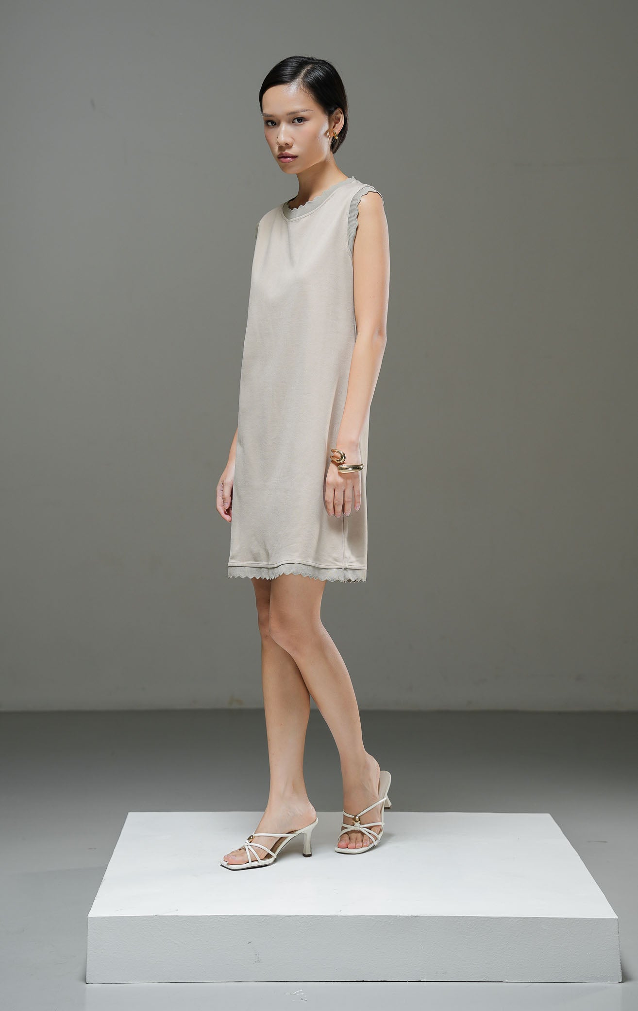 Dress wanita tanpa lengan Aileen Dress warna khaki cokelat muda potongan mini dress lurus dengan detail lis scallop gelombang di leher dan lengan. 
