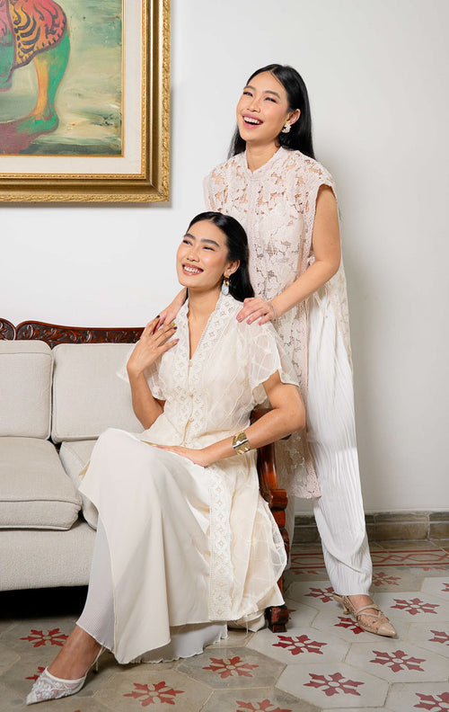 Model mengenakan Aleeya Outer Pink, luaran rompi panjang bahan lace 
motif bunga dengan detail tali pita samping dan renda yang feminin.