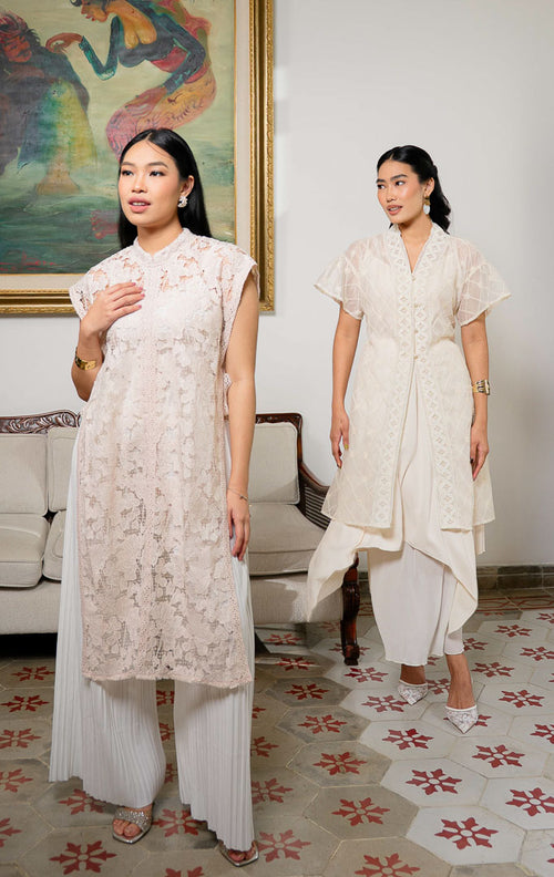 Model mengenakan Aleeya Outer Pink, luaran rompi panjang bahan lace 
motif bunga dengan detail tali pita samping dan renda yang feminin.