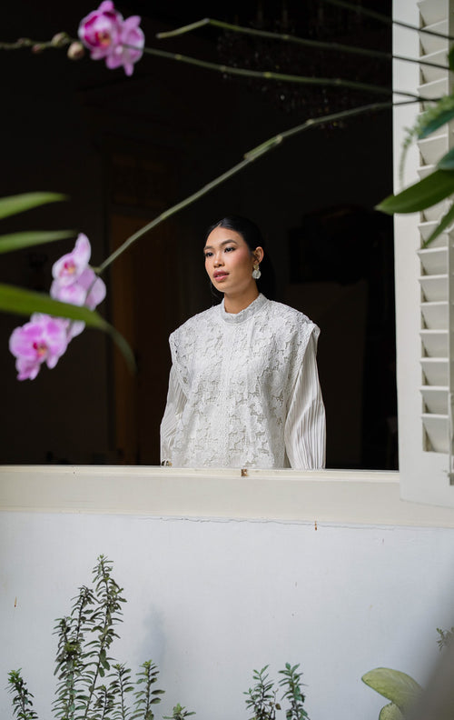 Aleeya Outer White, rompi panjang wanita bahan lace motif bunga warna 
putih dengan kerah tinggi dan detail transparan yang cocok untuk layering.