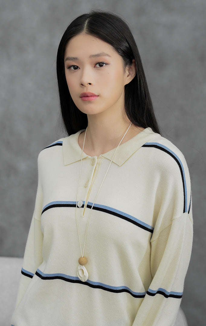 Sweter rajut wanita kerah polo warna ivory Alexis Sweater bermotif garis-garis (striped) dengan bukaan kancing depan (button closure) berbahan lembut dan stretchy.