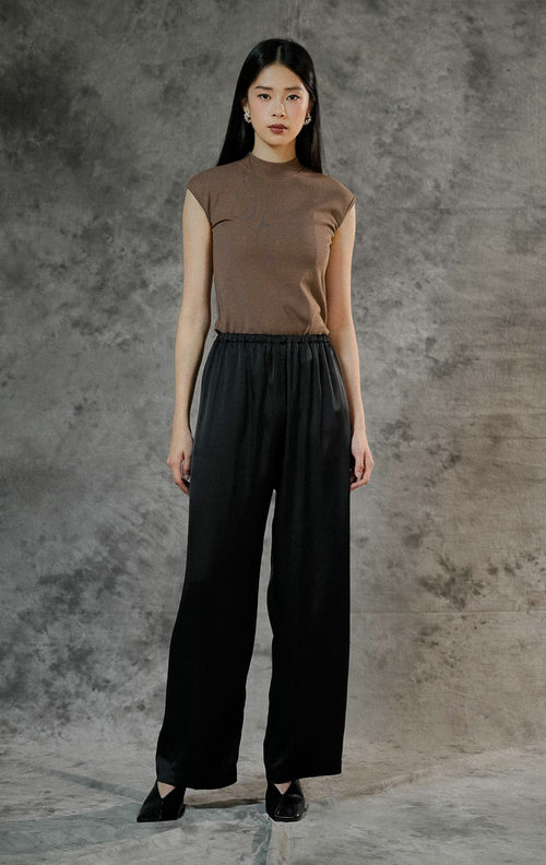 Celana panjang wanita Alonie Pants Black berbahan satin polos premium warna hitam dengan detail pinggang karet elastis untuk gaya casual chic. 