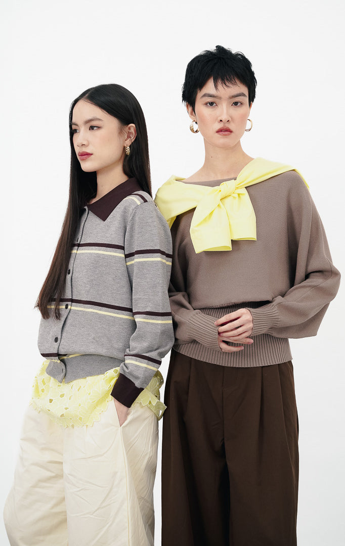 Model mengenakan Alyna Sweater warna grey, sweater rajut lengan panjang berkerah dengan motif garis horizontal warna cokelat dan kuning.