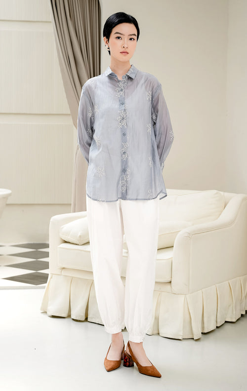 Atasan kemeja wanita Amaranth Top warna dusty blue berbahan cotton voile transparan (sheer) dengan motif bordir (embroidery) dan kancing depan style feminine & elegant. 