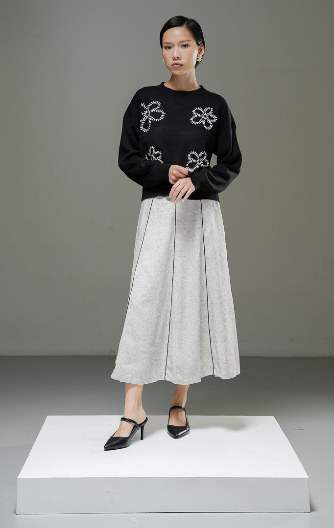 Sweater rajut wanita Amora Sweater warna hitam lengan panjang dengan motif bordir bunga besar, kerah bulat, dan detail ribbed hem. 