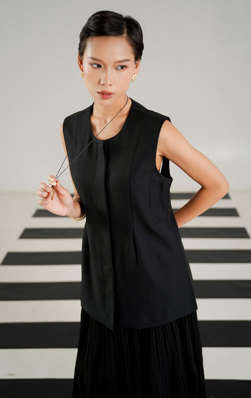 Atasan outerwear wanita Arcelia Vest Black dengan kerah lebar, lengan pendek, dan detail resleting depan dari This Is April. 
