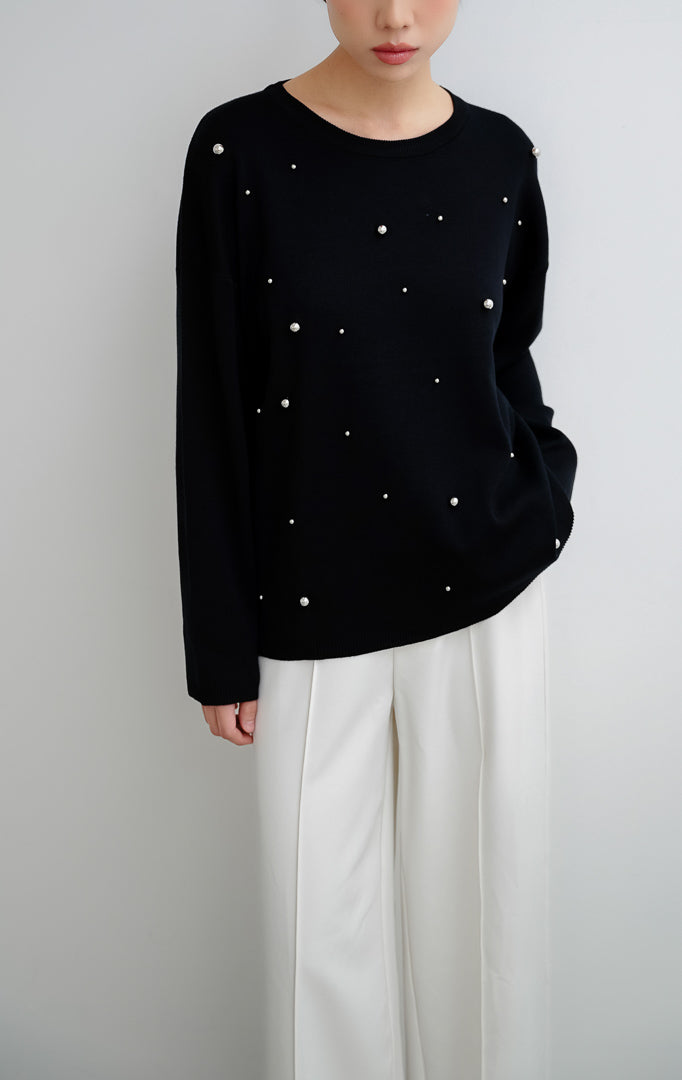 Sweater rajut wanita warna hitam Ardena Sweater dengan aksen hiasan metal studs, kerah bulat (round neckline), lengan panjang, dan potong relaxed fit.