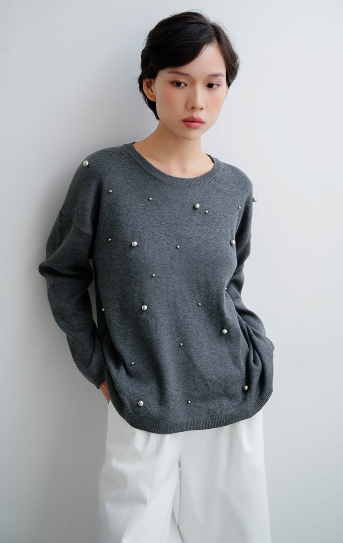 Sweater rajut wanita warna abu-abu tua (dark grey) Ardena Sweater dengan aksen hiasan metal studs, kerah bulat (round neckline), dan potongan relaxed fit.