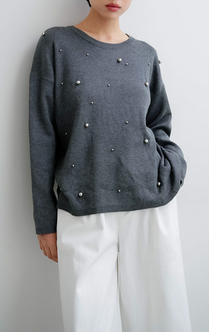 Sweater rajut wanita warna abu-abu tua (dark grey) Ardena Sweater dengan aksen hiasan metal studs, kerah bulat (round neckline), dan potongan relaxed fit.