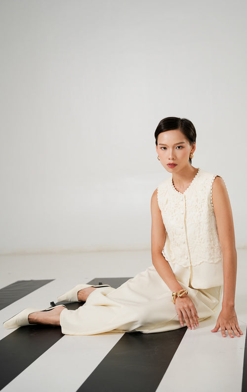 Close up rompi wanita Aster Vest Ivory dengan detail bahan floral jacquard dan kancing depan dari This Is April. 