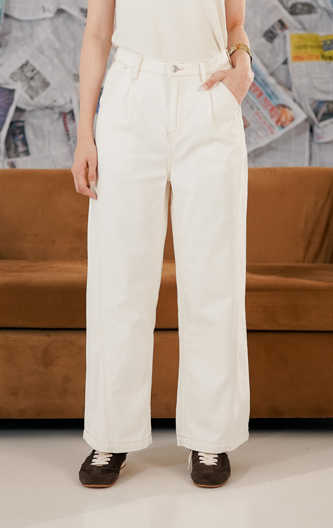 Model wanita mengenakan Atlanta Pants White, sebuah celana panjang denim warna putih (white jeans) dengan potongan lurus dan clean look. Celana memiliki saku depan fungsional dan dipadukan dengan atasan camisole serta sepatu sneakers untuk gaya kasual modern.