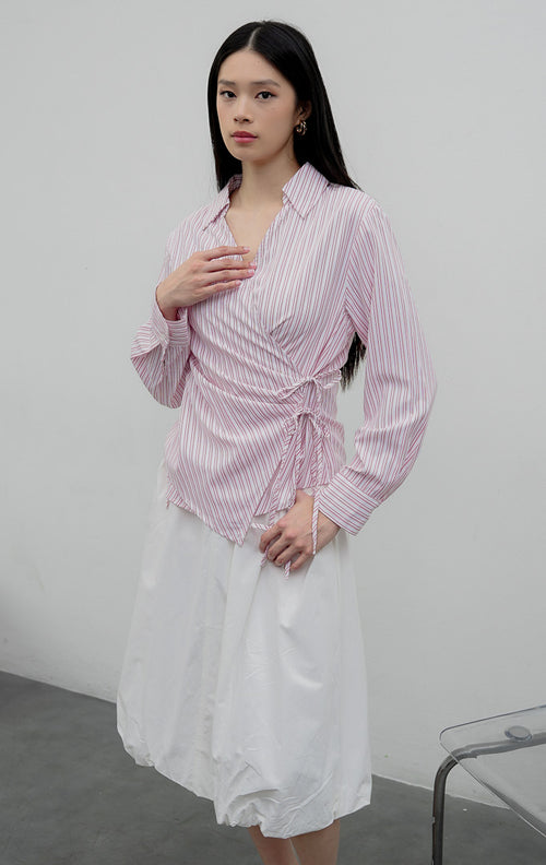 Kemeja wanita lengan panjang warna merah muda (pink) Audreyna Top berbahan campuran katun-poliester terstruktur dengan kerah V-neck, aksen ikatan tali pita (tie detail), dan bukaan kancing depan.