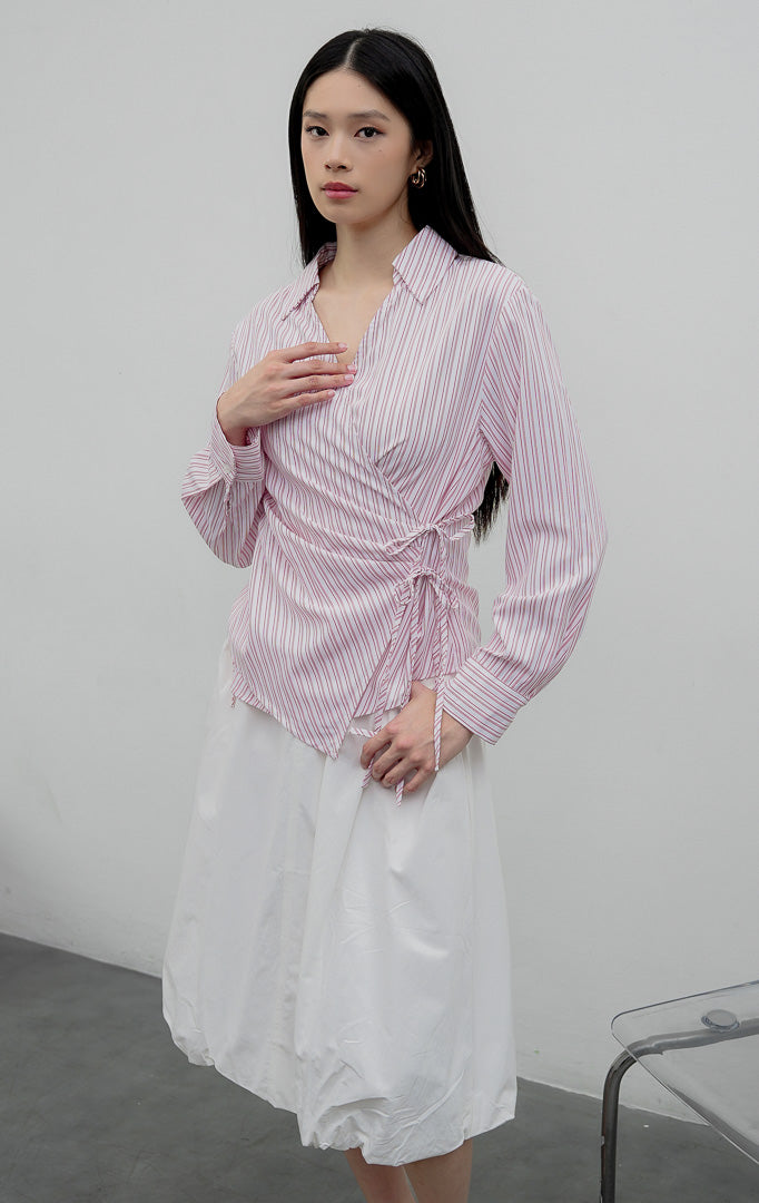 Kemeja wanita lengan panjang warna merah muda (pink) Audreyna Top berbahan campuran katun-poliester terstruktur dengan kerah V-neck, aksen ikatan tali pita (tie detail), dan bukaan kancing depan.