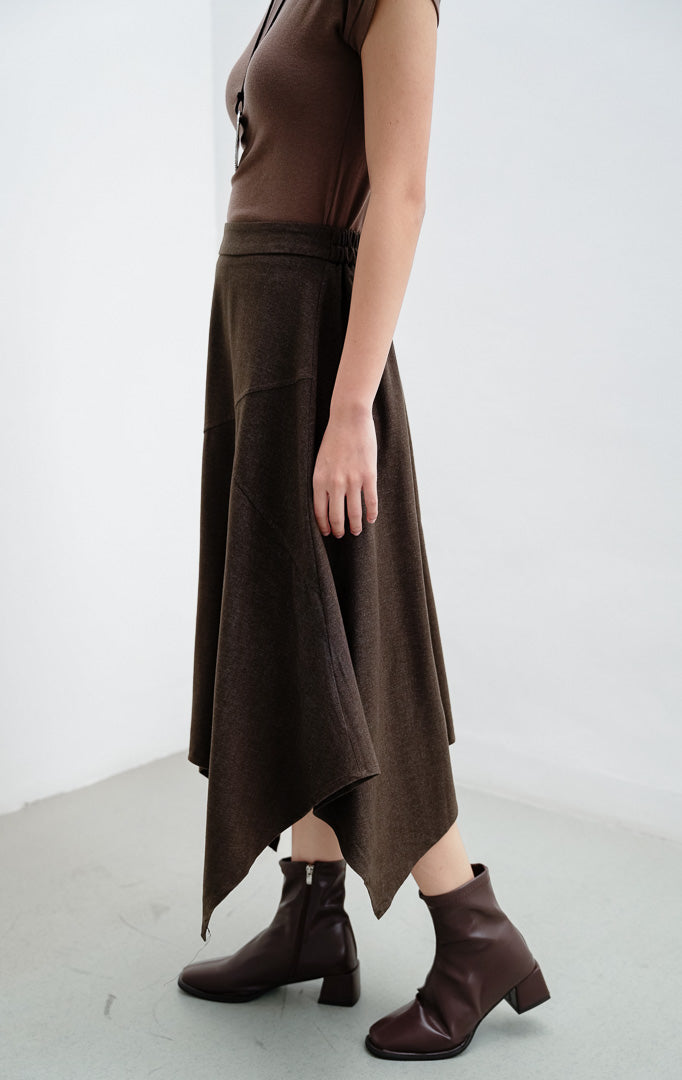 Rok midi wanita warna cokelat tua (dark brown) Austyn Skirt berbahan katun ringan dengan potongan hem asimetris dan pinggang karet (elasticated waistband).