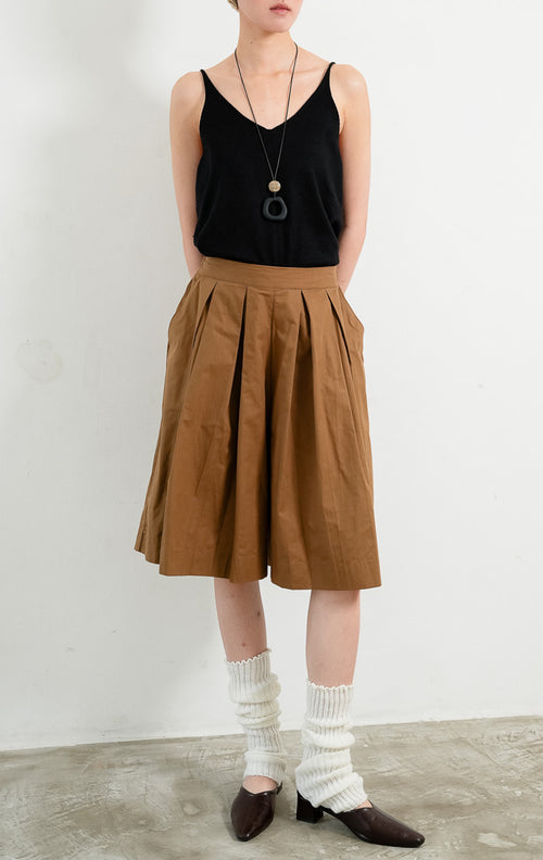 Celana kulot wanita santai warna cokelat (brown relaxed culotte pants) Avila Pants dengan pinggang bersih (clean waistband), detail lipit di bagian depan (subtle front pleat detailing), dan potongan kaki lebar (wide-leg silhouette).

