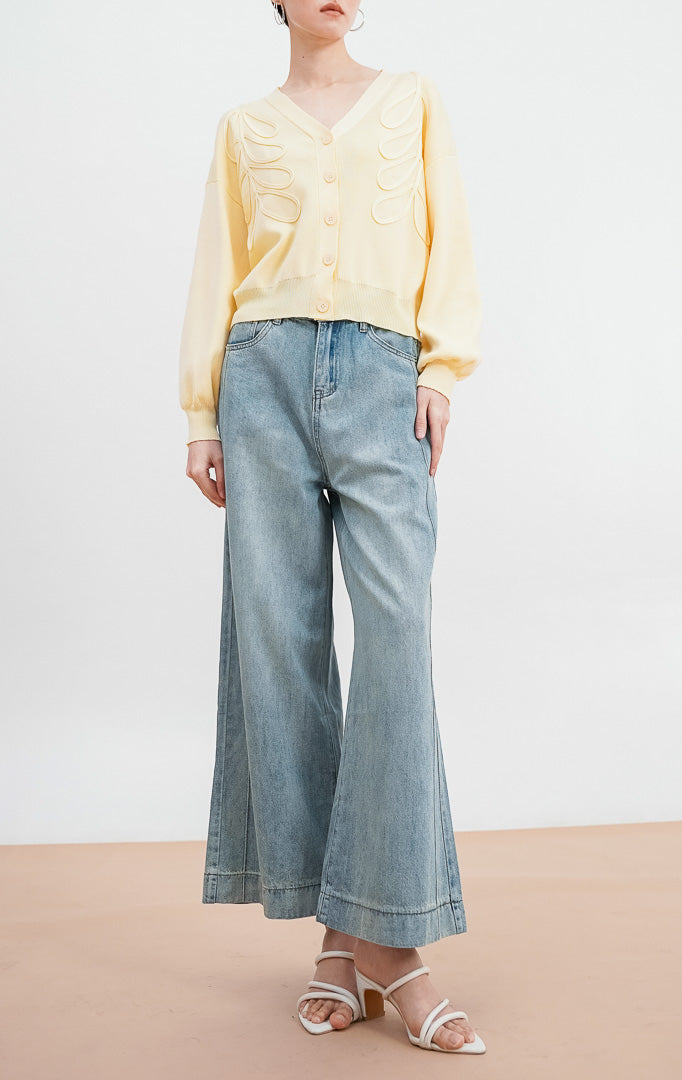 Model mengenakan Bailey Cardigan warna butter yellow, kardigan rajut V neck dengan detail bordir bunga timbul yang elegan dan kancing depan warna senada.