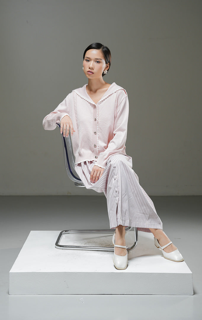 Cardigan rajut wanita Berenice Cardigan warna light pink merah muda lembut lengan panjang dengan kerah pelaut (sailor collar), aksen renda putih, dan kancing depan. 