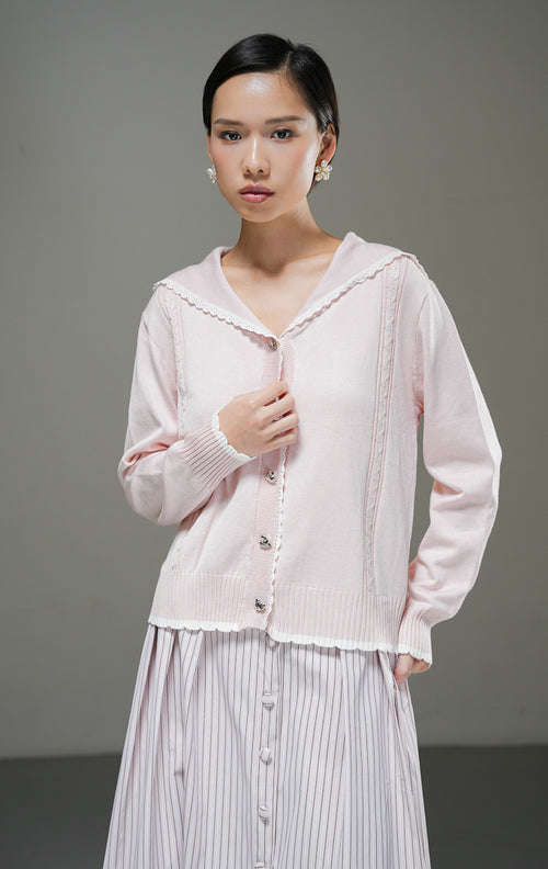 Cardigan rajut wanita Berenice Cardigan warna light pink merah muda lembut lengan panjang dengan kerah pelaut (sailor collar), aksen renda putih, dan kancing depan. 
