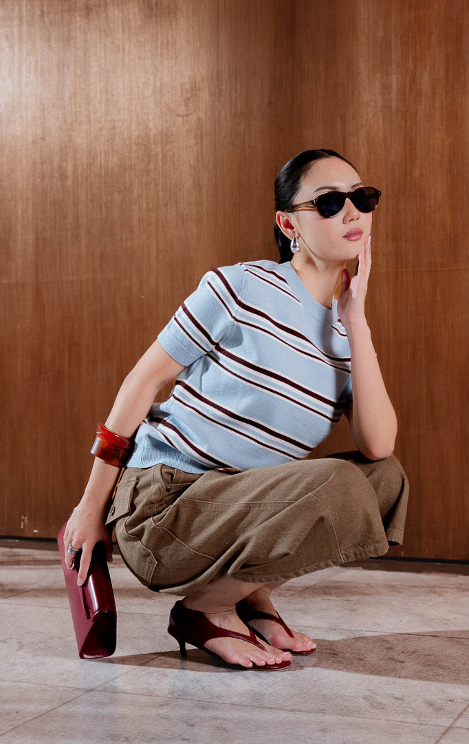 Kaos rajut wanita lengan pendek warna biru muda dengan detail motif garis melingkar (concentric stripe detailing in light blue), leher o-neck berusuk (ribbed crew neckline), dan bahan rajut elastis yang nyaman (stretchy knit fabric).