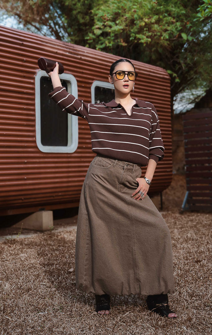 Sweater rajut wanita lengan panjang motif garis warna cokelat tua (dark brown striped knit sweater) Grifina Sweater dengan siluet longgar santai (relaxed slouchy silhouette), kerah polo V-neck, dan bahan rajut elastis (stretchy knit).