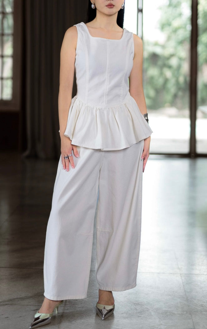 Celana denim panjang wanita warna putih bersih (white barrel-leg denim pants) Kernel Pants dengan siluet pinggang tinggi (high-waisted), potongan kaki melengkung (barrel-leg), serta karet elastis di bagian belakang pinggang.