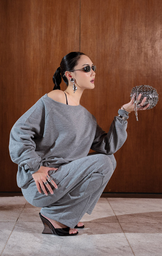 Sweatshirt wanita lengan panjang warna abu-abu (grey baby terry sweatshirt) Phyra Sweater dengan potongan bahu turun (relaxed drop-shoulder) dan tekstur rajutan baby terry yang ringan serta kasual.