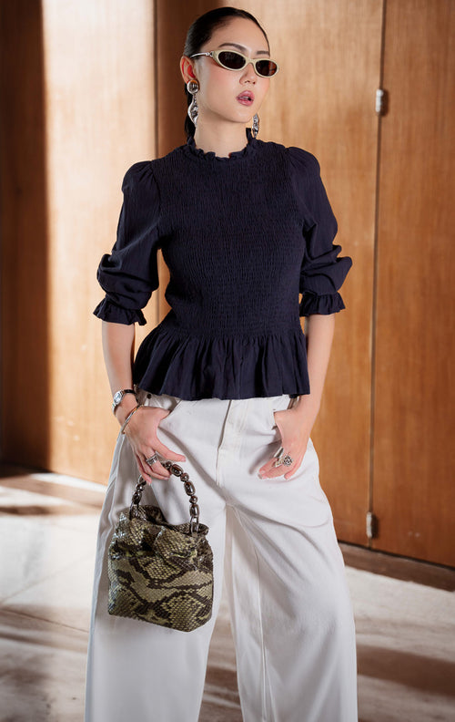 Blouse wanita lengan panjang warna navy (navy long sleeve blouse) Wynfield Top dengan bagian dada smock pas badan (flattering smocked bodice), siluet peplum mengembang lembut (softly flared peplum silhouette), serta bahan campuran katun linen bernapas (breathable cotton-linen blend).
